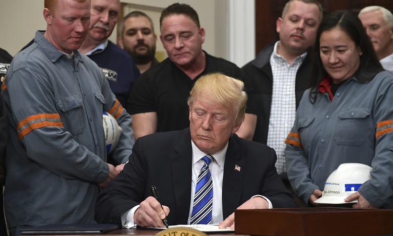 Tổng thống Donald Trump ký sắc lệnh trước sự chứng kiến của các công nhân ngành nhôm, thép tại Nhà Trắng ngày 8/3 (giờ địa phương). Ảnh: Guardian