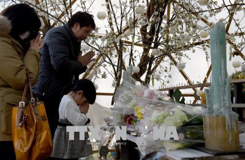 Một gia đình Nhật Bản cầu nguyện cho nạn nhân thảm họa động đất và sóng thần tại lễ tưởng niệm ở Tokyo ngày 11/3. AFP/TTXVN