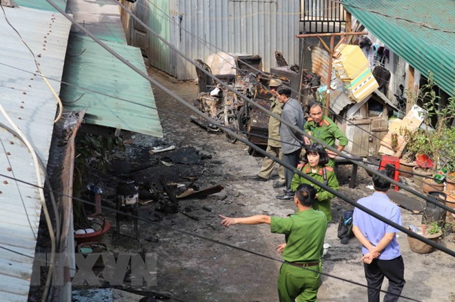 Lực lượng công an tiếp cận hiện trường vụ cháy tại khu nhà số 13 Trần Hưng Đạo khiến 5 người thiệt mạng trong tối 12/3. (Ảnh: Nguyễn Dũng/TTXVN)
