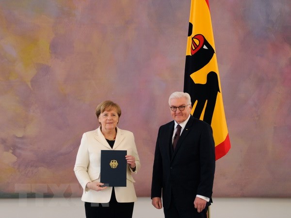 Bà Angela Merkel (trái) nhận quyết định bổ nhiệm từ Tổng thống Đức Frank-Walter Steinmeier sau khi tái đắc cử Thủ tướng Đức, tại Berlin ngày 14/3. (Nguồn: AFP/ TTXVN)