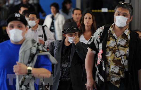 Khách du lịch sử dụng khẩu trang phòng dịch cúm lây lan tại sân bay quốc tế Los Angeles (Mỹ). (Nguồn: AFP/TTXVN)
