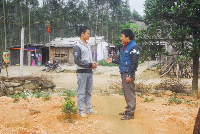 Anh Phùn Dảo Chăn (bên trái) trao đổi với cán bộ Đoàn xã Đồng Văn về phong trào thanh niên bản Sông Moóc A.