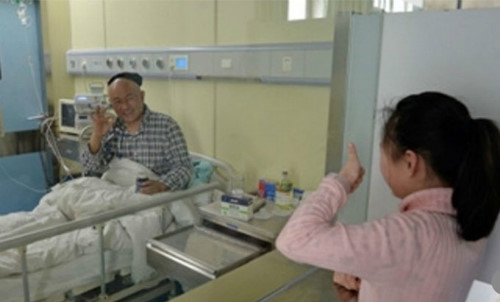 Khi đến thăm cha trong bệnh viện, cô bé đứng bên ngoài phòng bệnh và đưa ngón tay cái lên để cổ vũ cha. Đáp lại, anh Luo cũng giơ dấu hiệu 