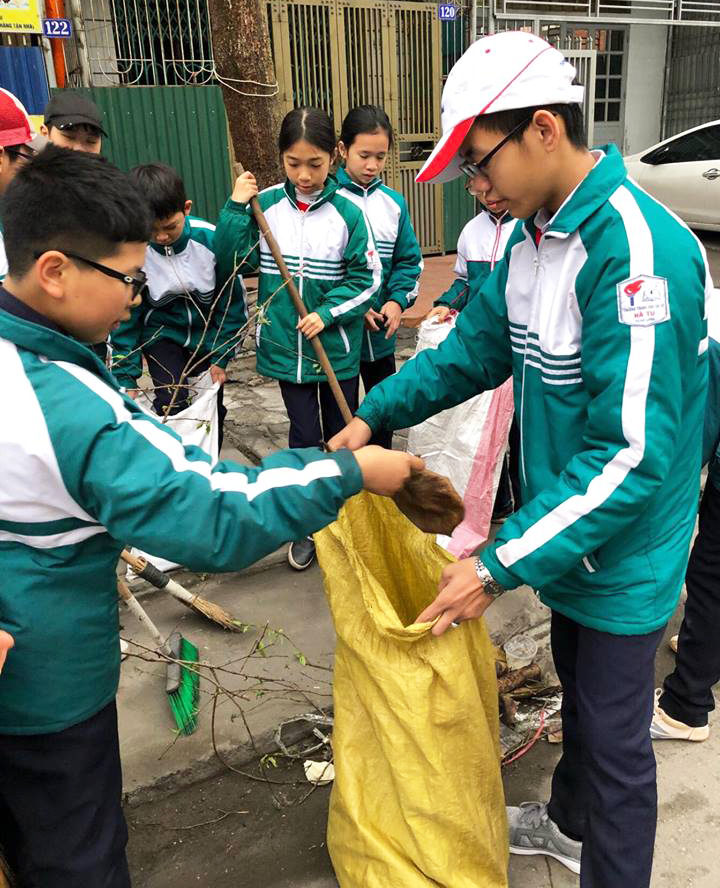 Học sinh trường THCS Hà Tu thực hiện dọn vệ sinh môi trường quang khu vực trường học và khu dân cư.