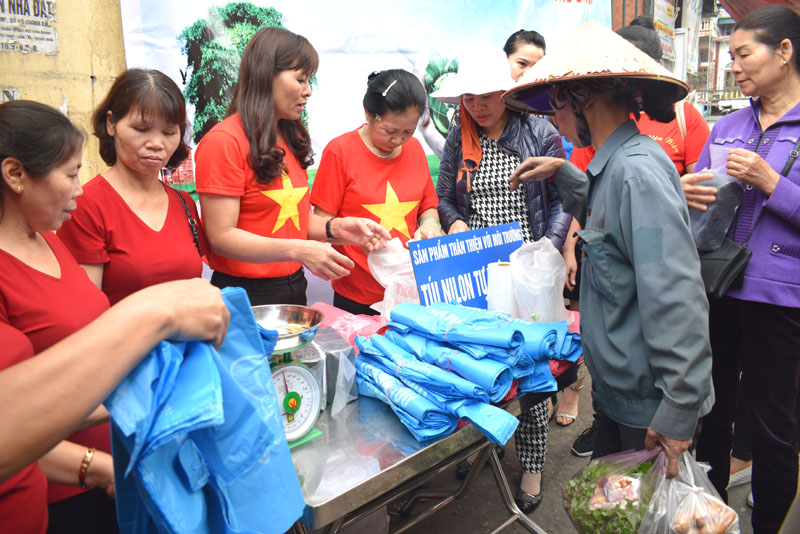 Các cán bộ Hội LHPN phường Cẩm Thịnh tuyên truyền sử dụng túi thân thiện môi trường ở phường Cẩm Phú