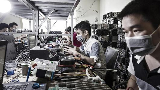 Các kỹ thuật viên đang sửa máy đào coin tại một cơ sở của Bitmain ở Nội Mông, Trung Quốc.