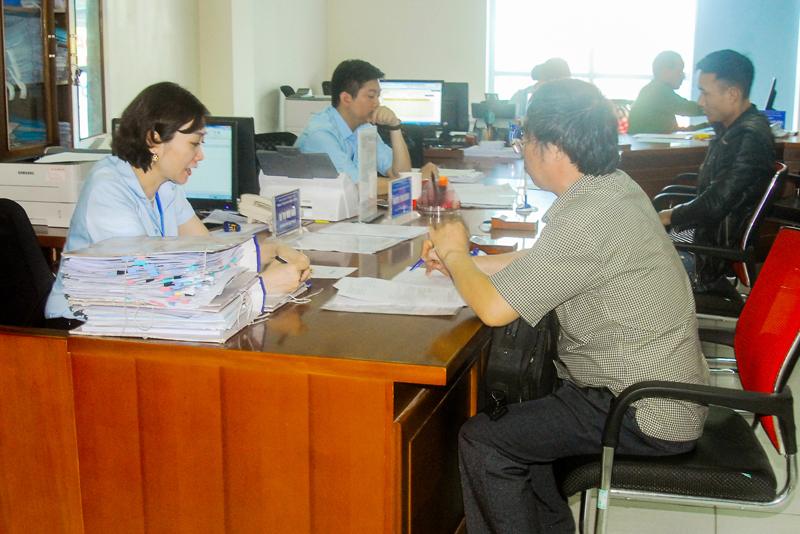Cán bộ Trung tâm HCC TP Hạ Long hướng dẫn người dẫn giải quyết TTHC.