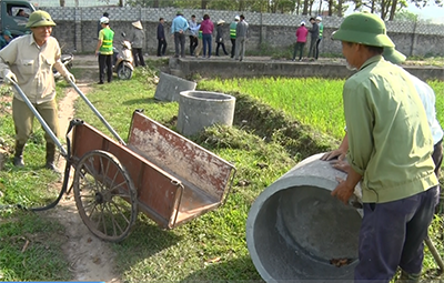 Người dân phường Nam Khê lắp đặt các thùng đựng vỏ, bao bì thuốc BVTV trên cánh đồng khu Trạp Khê.