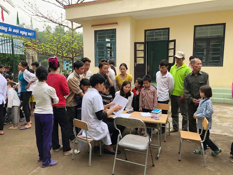 Các bác sỹ Trung tâm Y tế huyện khám, phát thuốc miễn phí cho người dân và trẻ em nghèo thôn Khe Và, xã Húc Động, huyện Bình Liêu.