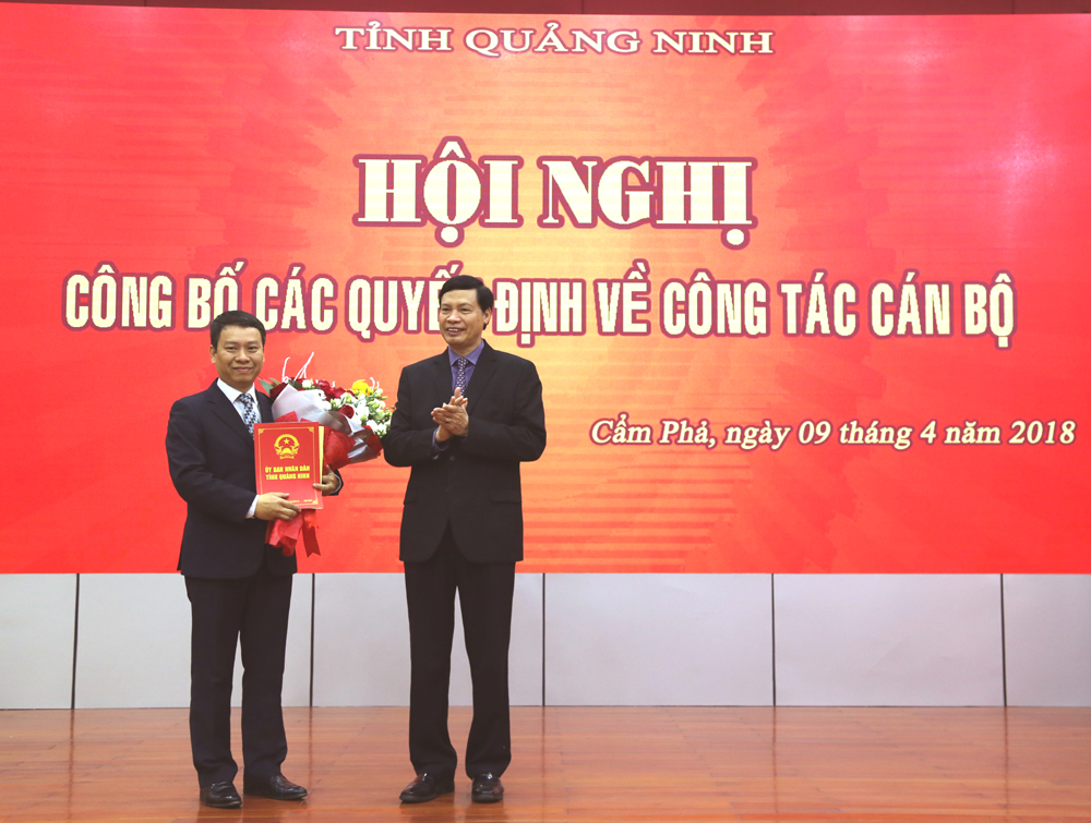 Đồng chí Nguyễn Đưc Long, Phó Bí thư Tỉnh ủy, Chủ tịch UBND tỉnh, trao Quyết định và tặng hoa chúc mừng đồng chí Nguyễn Ngọc Dương.