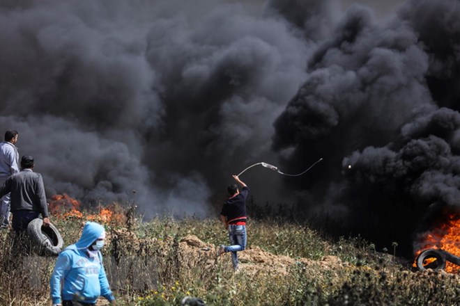Người biểu tình Palestine đốt lốp xe và ném đá vào binh sỹ Israel trong cuộc biểu tình dọc biên giới giữa khu vực phía Đông Dải Gaza và Israel. (Nguồn: THX/TTXVN)