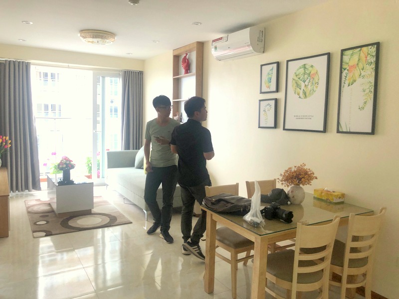 Đoàn Tùng Lâm (áo đen bên phải) đang giới thiệu về căn hộ Homestay của mình cho một du khách