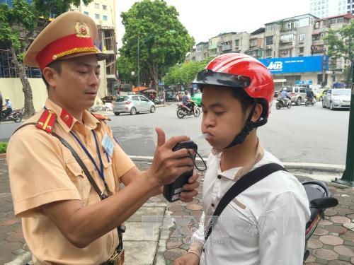 Cảnh sát giao thông Đội 1, Phòng Cảnh sát giao thông Hà Nội tiến hành kiểm tra nồng độ cồn của điều khiển phương tiện tại ngã tư Trần Hưng Đạo - Lê Thánh Tông. Ảnh: Doãn Tấn/TTXVN