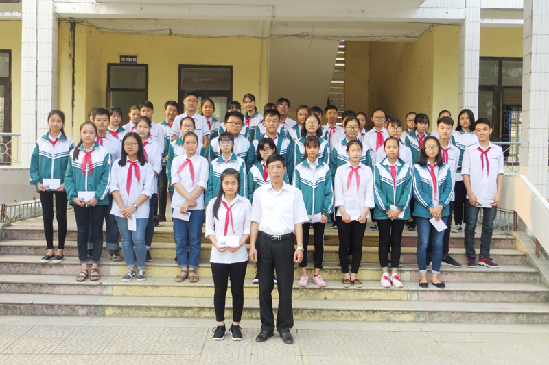 Thầy hiệu trưởng trường THCS thị trấn Trới trao thưởng cho em Lê Thị Thùy Linh