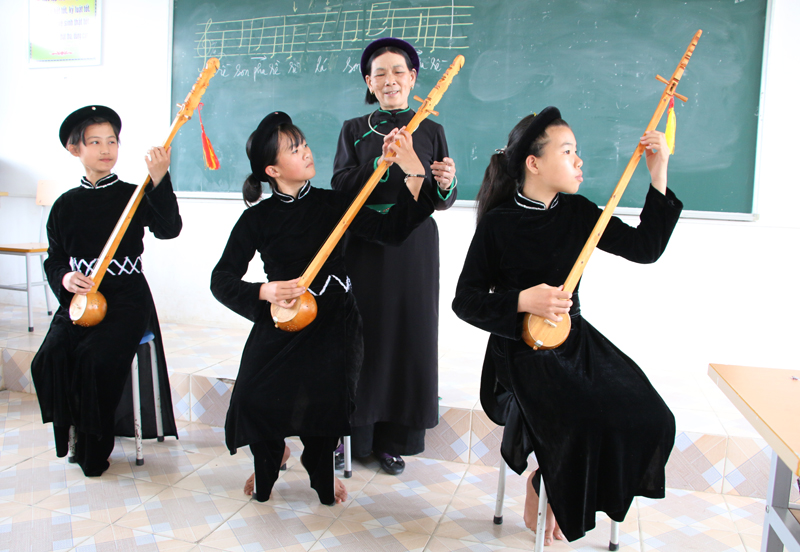 Nghệ nhân Hoàng Thị Viên (thứ 3, trái sang) dạy hát Then, đánh đàn Tính cho trẻ em địa phương.