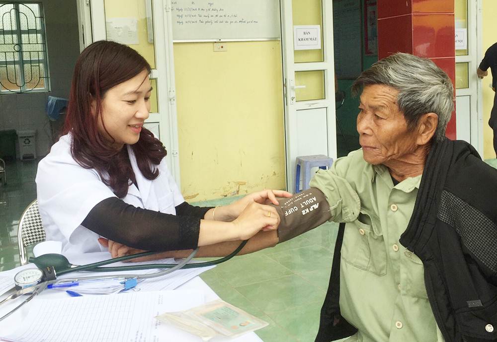 Nhân viên y tế Bệnh viện Đa khoa tỉnh đang đo huyết áp cho người dân xã Bắc Sơn, TP Móng Cái.
