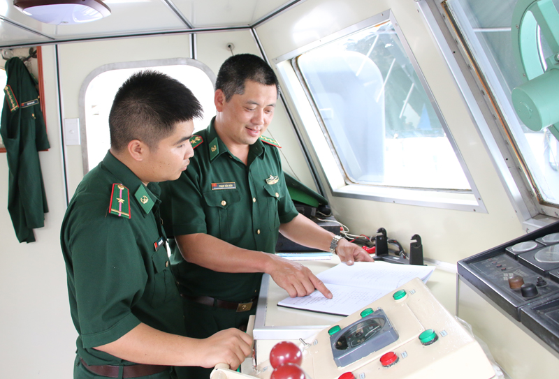 Đại úy Phạm Văn Hân (bên phải) trao đổi với đồng đội về một số phương pháp sửa chữa máy tàu.