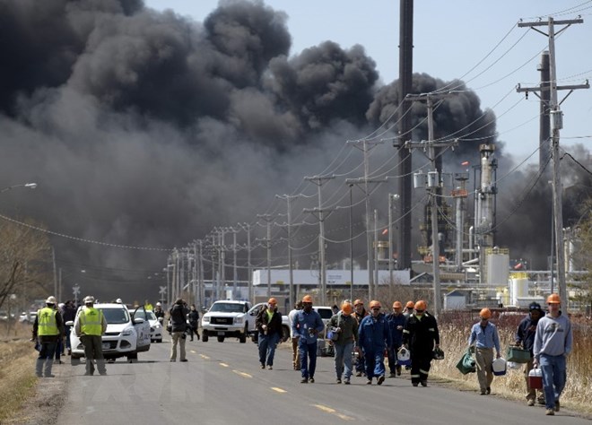 Khói bốc lên dày đặc từ hiện trường vụ nổ nhà máy lọc dầu Husky Energy. (Nguồn: AFP/TTXVN)