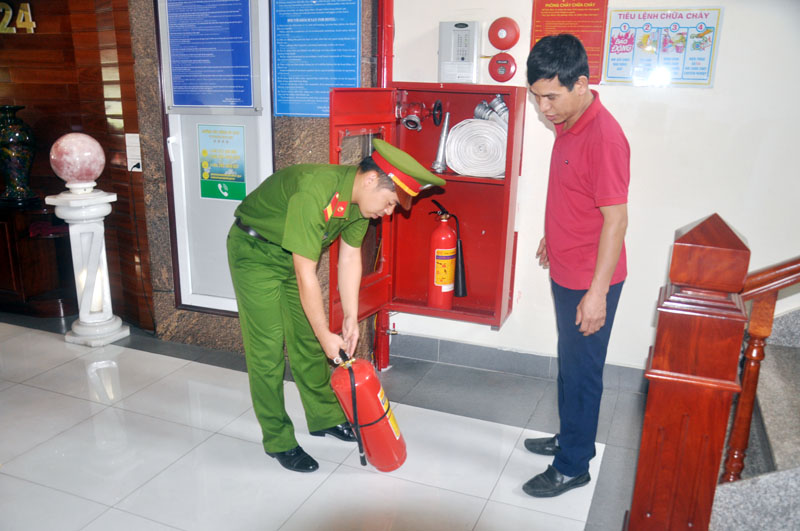 Cán bộ Phòng Cảnh sát PCCC số 2 hướng dẫn nhân viên khách sạn Việt Hoàng 24, phường Cẩm Đông (TP Cẩm Phả) sử dụng bình chữa cháy tại chỗ