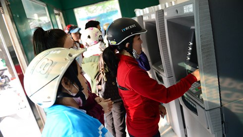 Công nhân rút tiền tại ATM trong Khu chế xuất Tân Thuận, quận 7, TP.HCM - (Ảnh: Quang Định)