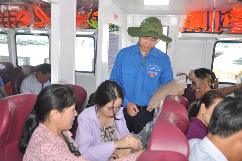 Đoàn viên thanh niên huyện Cô Tô phát túi giấy, tuyên truyền cho du khách không mang túi nilon lên đảo để bảo vệ môi trườn