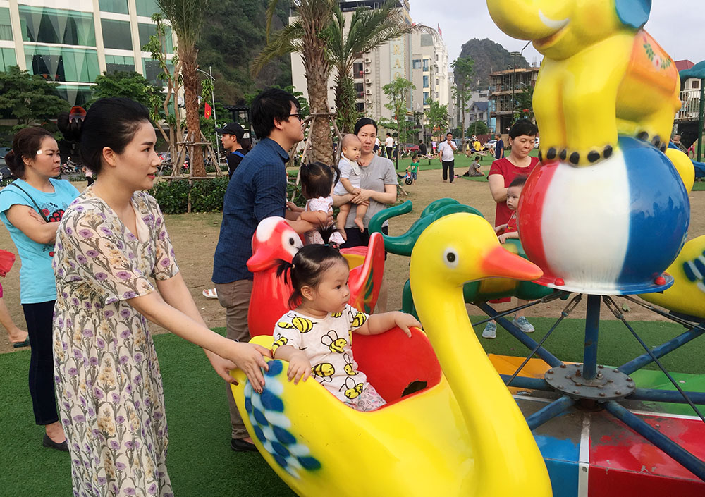 Trẻ em chơi đu quay tại Khu vui chơi cho thiếu nhi trong Công viên hoa Hạ Long (TP Hạ Long)