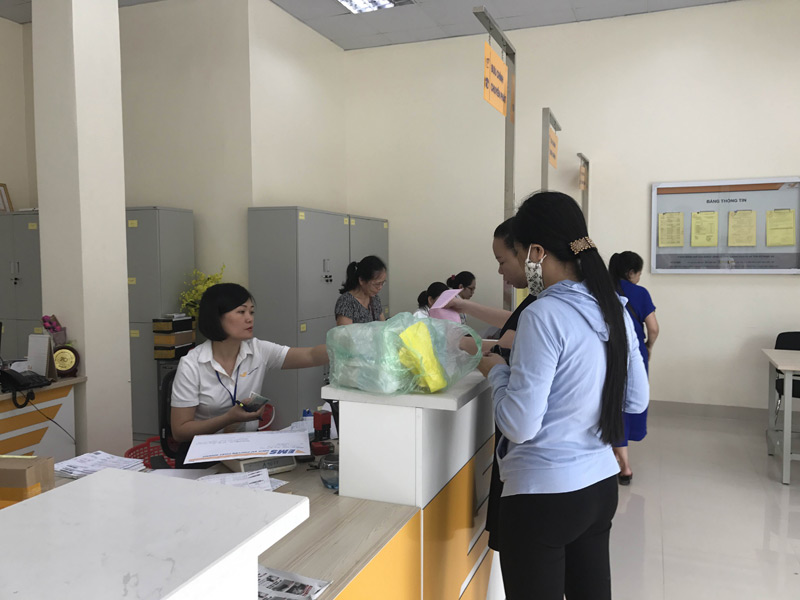 Nhân viên Bưu điện trả giấy tờ cho người dân thông qua hệ thống chuyển phát 
