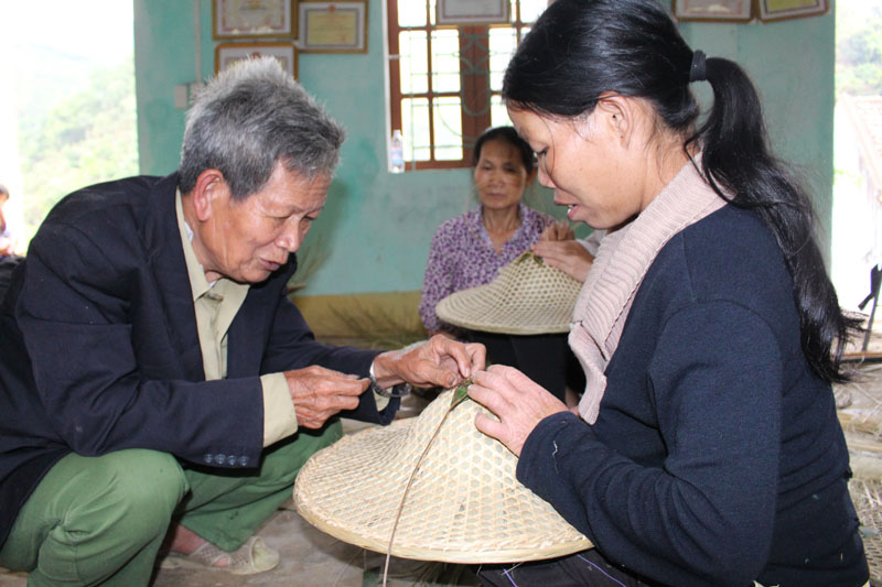 Ông Chíu Dì Lồng (78 tuổi) đang truyền nghề đan nón cho các học viên.