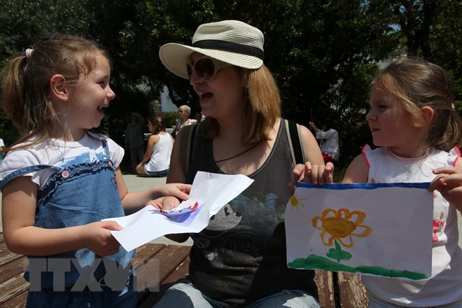Hai bé gái tặng quà cho mẹ trong Ngày của Mẹ tại Athens, Hy Lạp ngày 13/5. (Nguồn: THX/TTXVN)