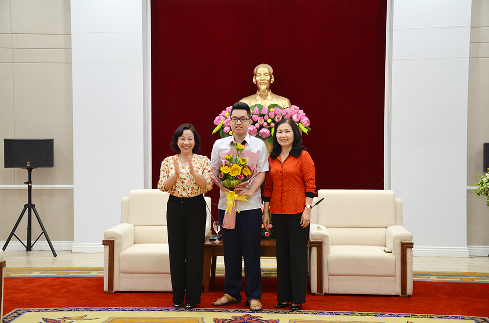 Đồng chí Vũ Thị Thu Thủy, Phó Chủ tịch UBND tỉnh, đại diện Hội Khuyến học tỉnh tặng hoa chúc mừng em Lê Kỳ Nam