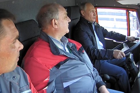 Tổng thống Putin ngồi sau vô lăng, không thắt dây an toàn, vừa lái xe tải vừa nói chuyện với người ngồi bên cạnh. Ảnh: RT.