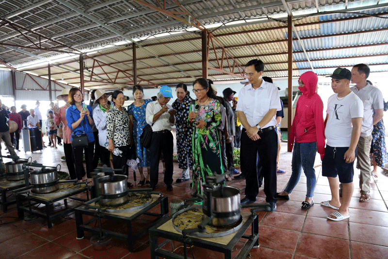 Nhân dân và du khách được nghe bà Hà Ngọc Quỳnh, Chủ cơ sở sản xuất chè Thuấn Quỳnh giới thiệu về quy trình 