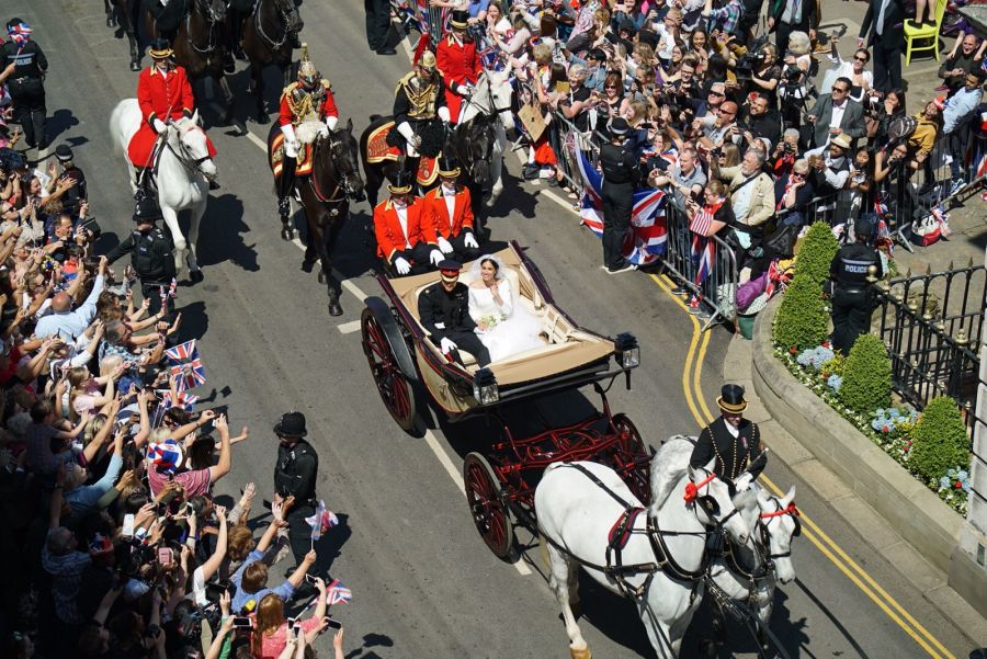 Công nương và công tước xứ Sussex vẫy chào người dân khi thực hiện lễ rước trên tuyến đường 3km quanh thị trấn Windsor.