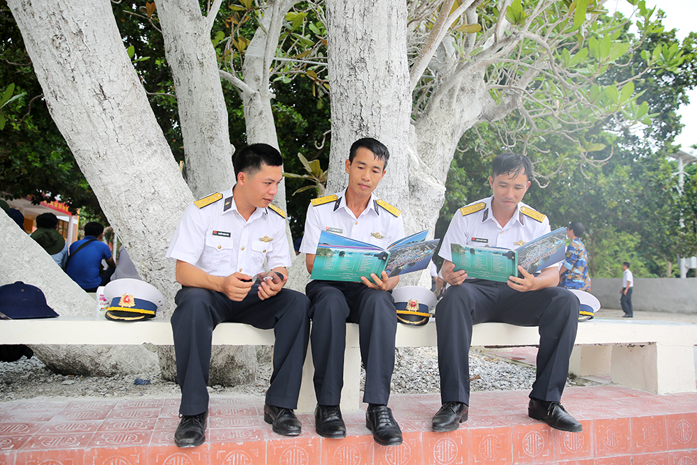 Các chiến sỹ là con em của Quảng Ninh trên đảo Nam Yết chuyền tay nhau ấn phẩm của quê hương trong giây phút giải lao.