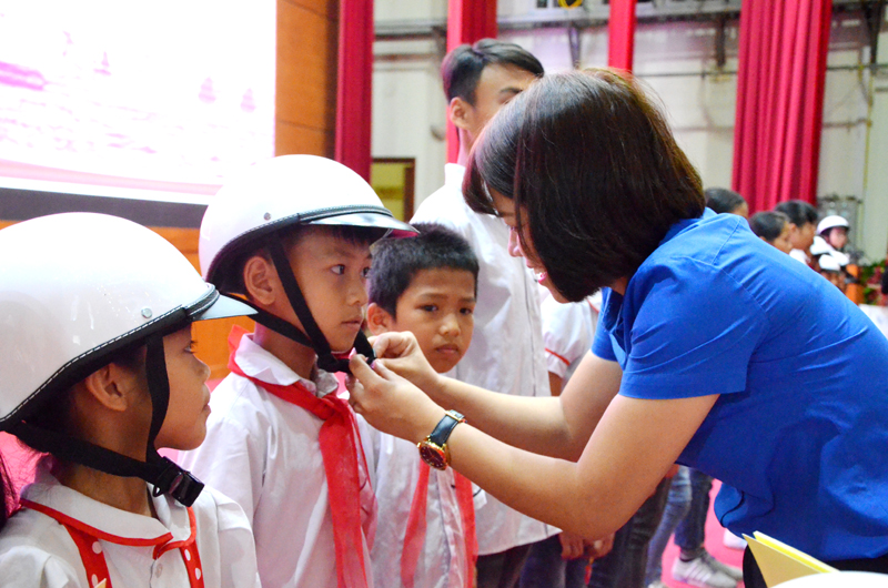 Đại diện lãnh đạo Tỉnh đoàn trao tặng mũ bảo hiểm cho trẻ em tại lễ phát động
