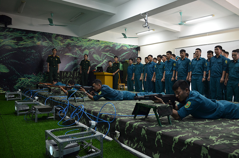 Giảng viên Trường Quân sự tỉnh dạy thực hành bắn súng cho học viên tại phòng bắn ảo