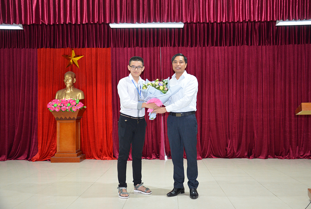 Đồng chí Vũ Văn Diện, Phó Chủ tịch UBND tỉnh tặng hoa chúc mừng học sinh Nguyễn Hoàng Cường