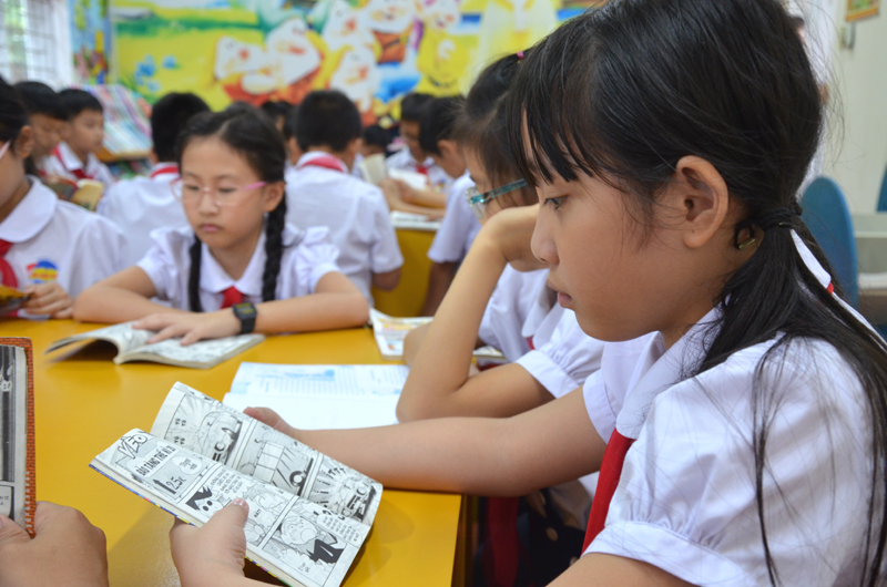 Học sinh trường tiểu học thị trấn Trới, huyện Hoành Bồ đọc sách và truyện tranh trong giờ ra chơi tại thư viện trường