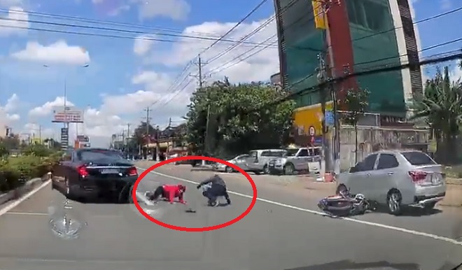 Tài xế bẻ lái xuất thần tránh đâm vào 2 người ngã ra đường. Ảnh cắt từ clip.