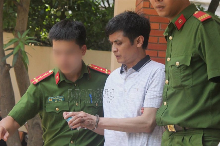 Cảnh sát dẫn giải ông Nguyễn Đình Lê (giáo viên Trường Tiểu học An Thượng A) ra xe sau khi kết thúc phiên tòa xét xử.