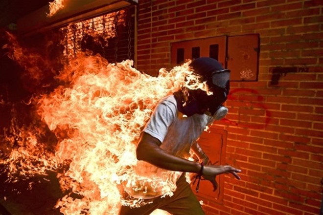 Bức ảnh Báo chí của năm: Người biểu tình Jose Victor Salazar Balza bốc cháy trong cuộc đụng độ với cảnh sát chống bạo động tại cuộc biểu tình chống lại Tổng thống Venezuela Nicolas Maduro, ở Caracas, Venezuela vào ngày 3.5.2017. Ảnh: Ronaldo Schemidt/AFP