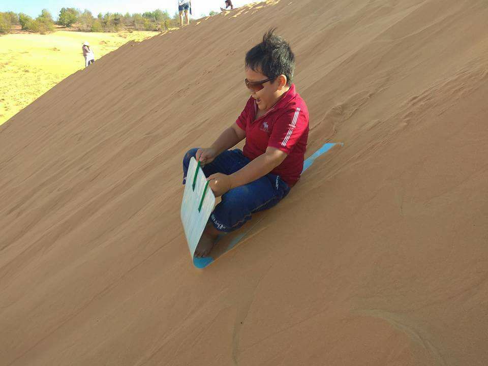Em nhỏ hào hứng tham gia trải nghiệm trượt cát ở Mũi Né.