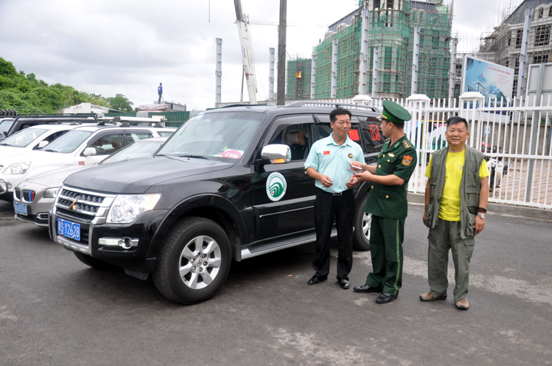 Cán bộ Đồn Biên phòng cửa khẩu quốc tế Móng Cái kiểm tra thủ tục của khách Trung Quốc đi xe tự lái vào Hạ Long (Quảng Ninh, Việt Nam)