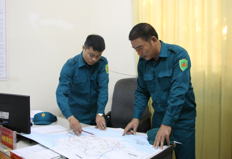 Cán bộ Ban CHQS phường Bãi Cháy rà soát trên bản đồ các khu vực có nguy cơ sạt lở. 