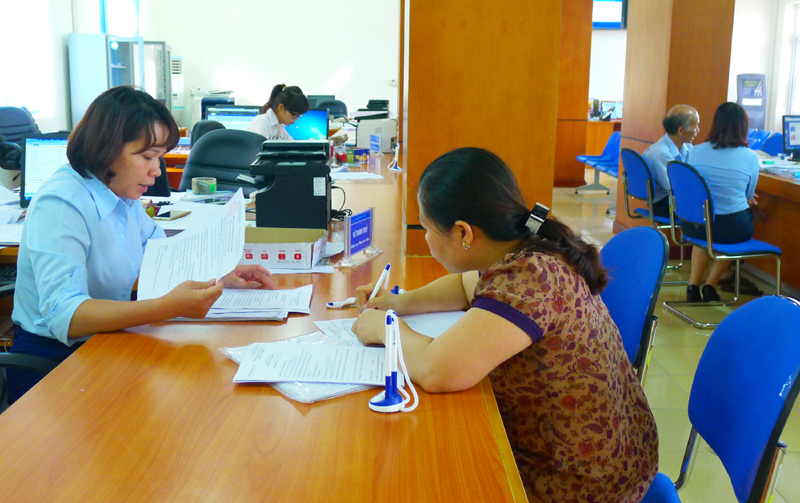 Cán bộ Trung tâm Hành chính công huyện Vân Đồn hướng dẫn người dân thực hiện các thru tục trên hệ thống kiot điện tử