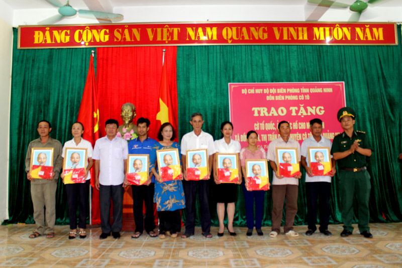Nhân dân xã Đồng Tiến và thị trấn Cô Tô nhận cờ Tổ quốc và ảnh Bác Hồ do Đồn BP Cô Tô trao tặng.