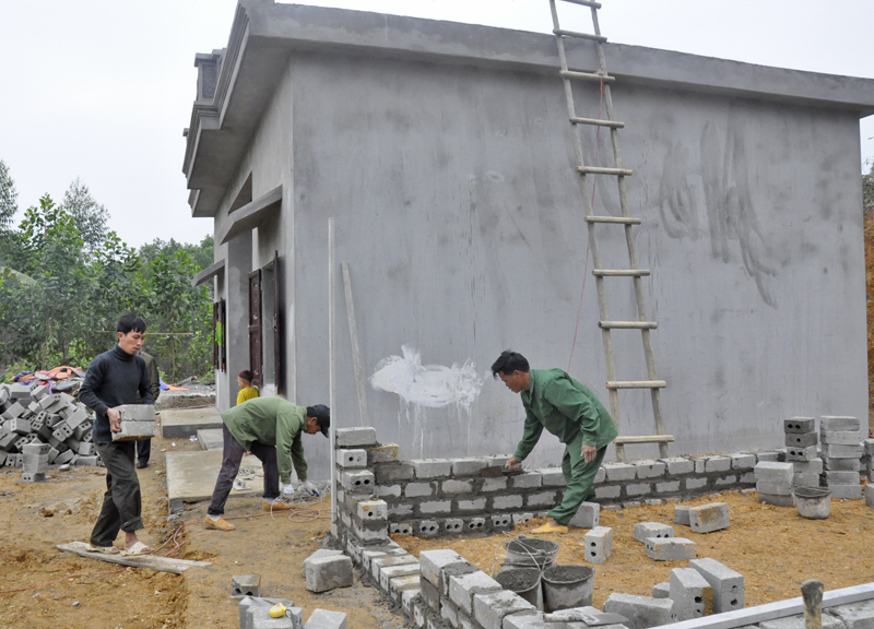 Người dân trong xã giúp gia đình anh Phàng A Ửng, bản Lồ Má Coọc, xã Quảng Sơn (Hải Hà) xây dựng bếp sau khi anh đã hoàn thiện nhà ở theo chương trình 167. 