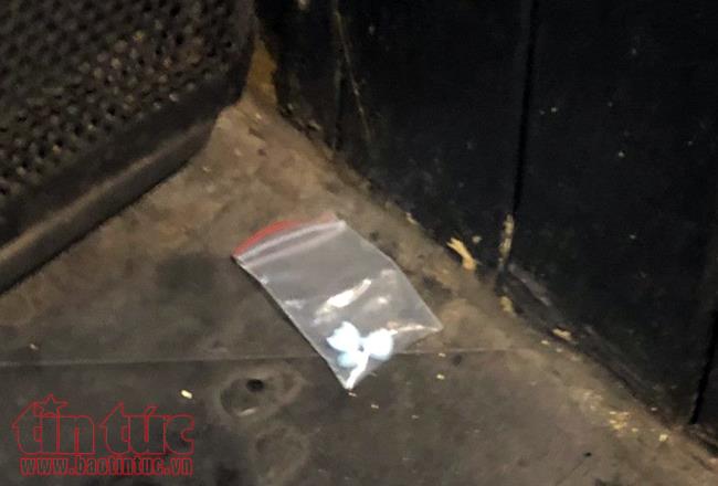 Nhiều túi nylon chứa viên nén nghi ma túy được các đối tượng ném dưới sàn.