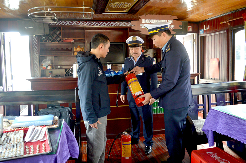 Cán bộ Cảng vụ thủy nội địa tuyên truyền, kiểm tra thiết bị phòng cháy chữa cháy cho chủ tàu trên vịnh.