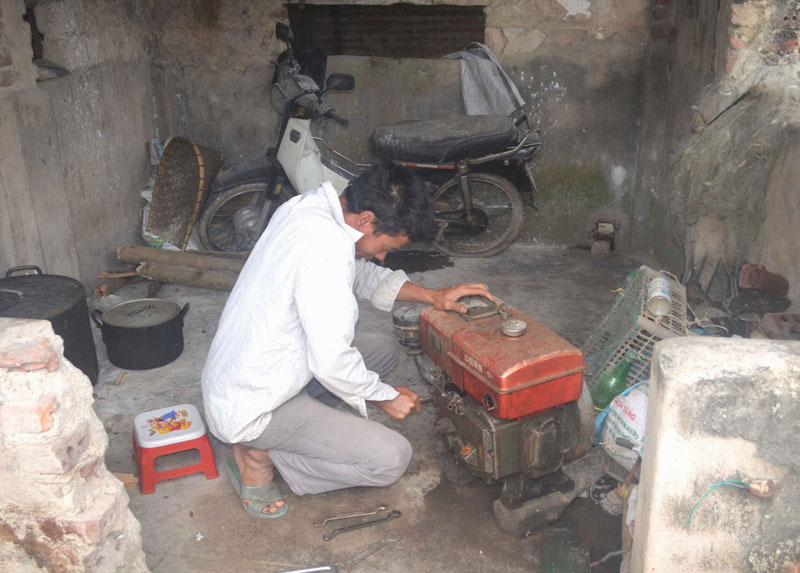 Anh Dũng sau khi qua lớp học nghề sửa chữa máy đã có khoản thu từ sửa chữa máy cho người trong thôn